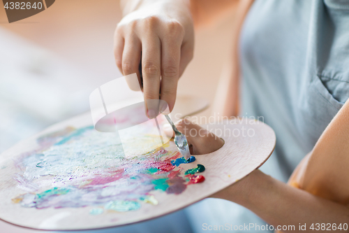 Image of artist with palette knife painting at art studio