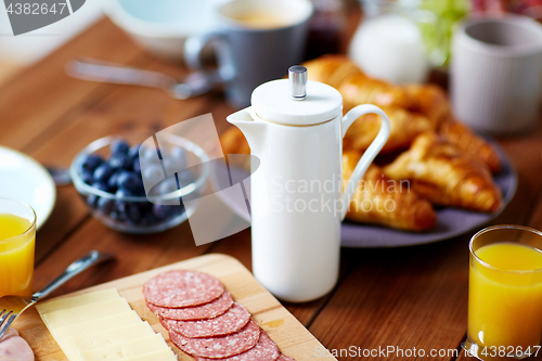 Image of coffee pot and food on served table at breakfast