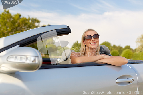 Image of happy young woman in convertible car