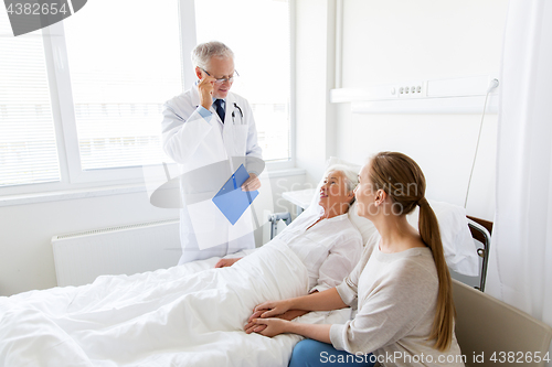 Image of senior woman and doctor with clipboard at hospital