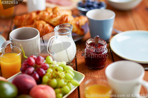 Image of jar with jam on wooden table at breakfast