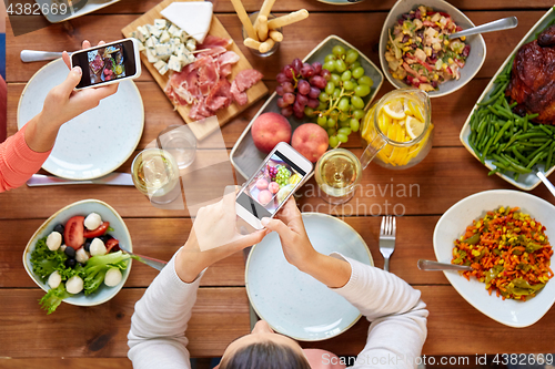 Image of people with smartphones photographing food