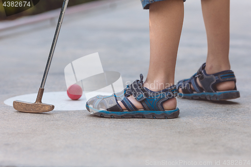 Image of Happy little boy  playing mini golf.