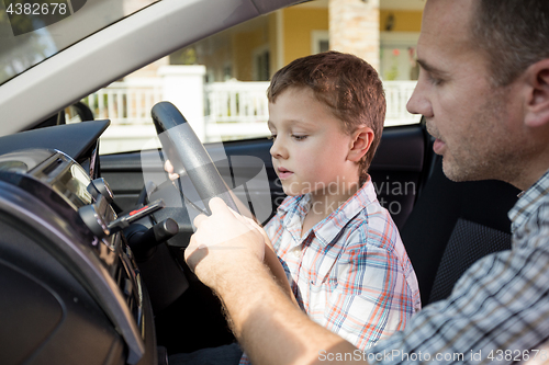 Image of Happy father and son sitting in the car at the day time.