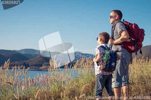 Image of Happy family standing near the lake at the day time.