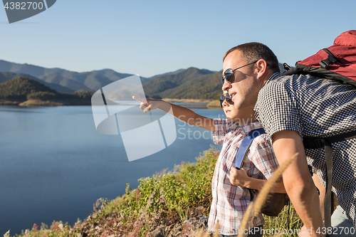 Image of Happy family standing near a lake at the day time.