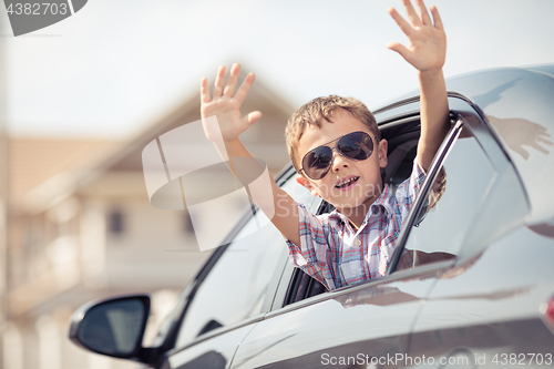 Image of One happy little boy sitting in the car.