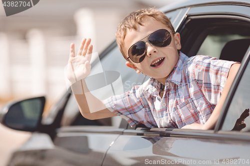 Image of One happy little boy sitting in the car.