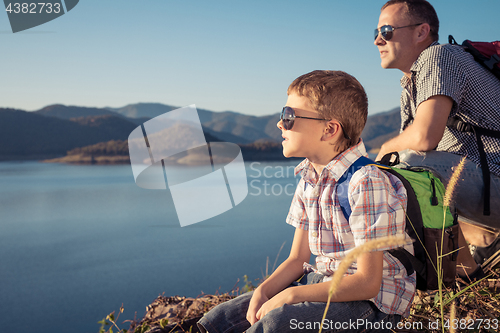 Image of Happy family sitting near a lake at the day time.