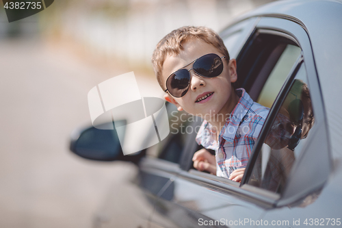 Image of One happy little boy sitting in the car.