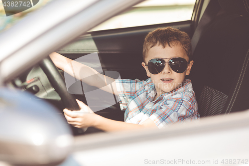 Image of One happy little boy sitting in the car.