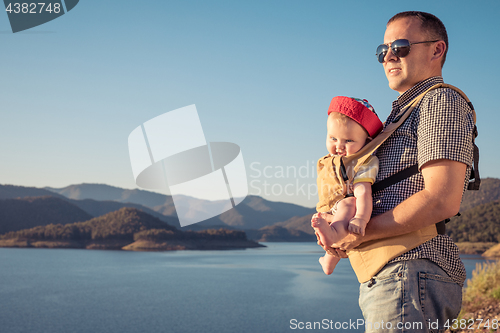 Image of Happy family standing near the lake at the day time.