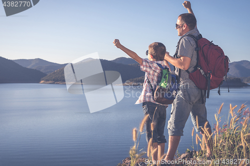 Image of Happy family standing near the lake at the day time.