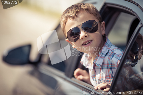 Image of One happy little boy sitting in the car.