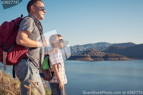 Image of Happy family standing near a lake at the day time.