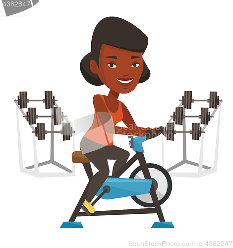 Image of Young woman riding stationary bicycle.