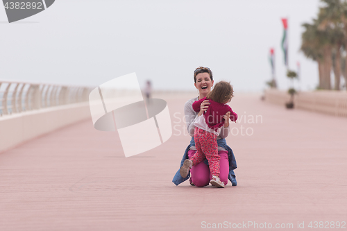 Image of mother and cute little girl on the promenade by the sea