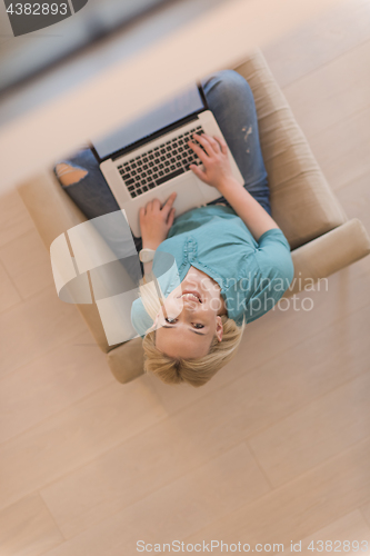 Image of Young woman using laptop at home top view