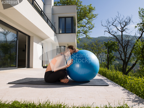Image of woman doing exercise with pilates ball