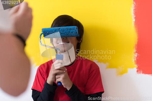 Image of young boy painter with paint roller