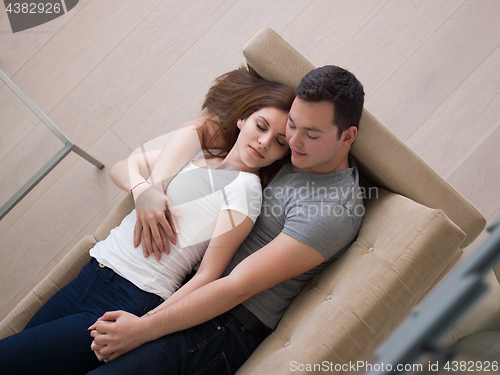 Image of young handsome couple hugging on the sofa