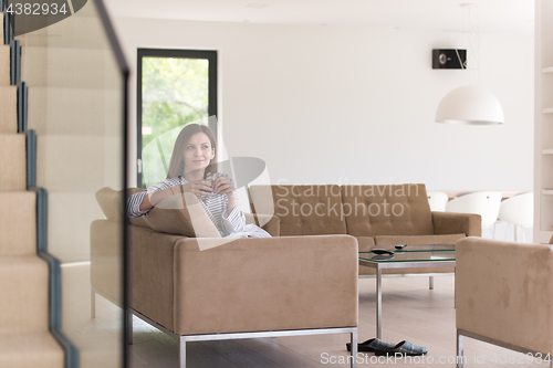 Image of young woman in a bathrobe enjoying morning coffee