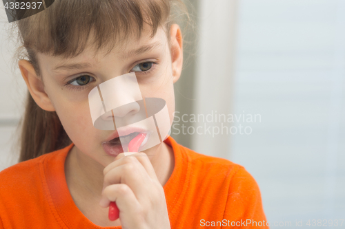 Image of Seven-year-old girl enthusiastically brushes teeth