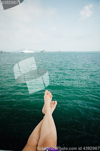 Image of Crop female feet above sea water