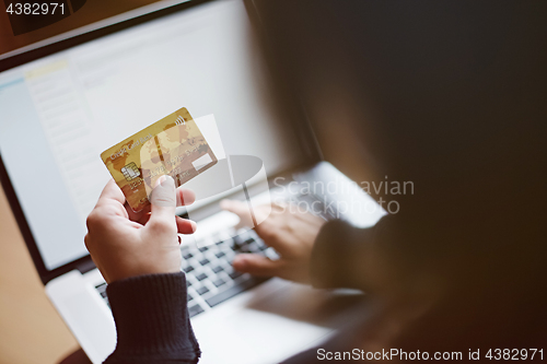 Image of Woman using credit card for online purchase