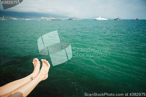 Image of Crop female feet above sea water