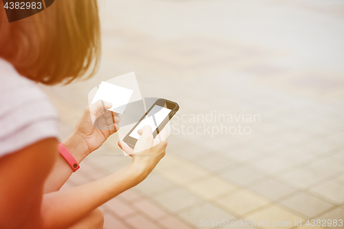 Image of Woman using phone and card for shopping