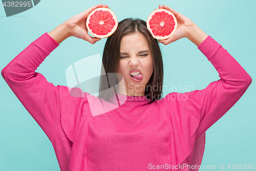 Image of Pretty woman with delicious grapefruit in her arms.