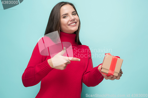 Image of Portrait of happy young woman holding a gift isolated on white