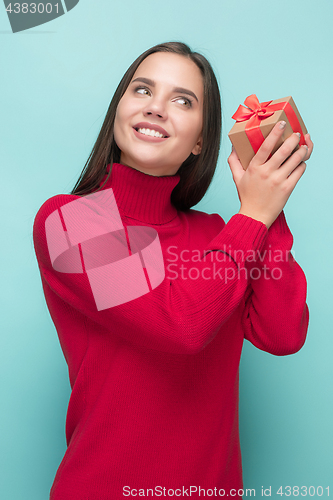 Image of Portrait of happy young woman holding a gift isolated on white