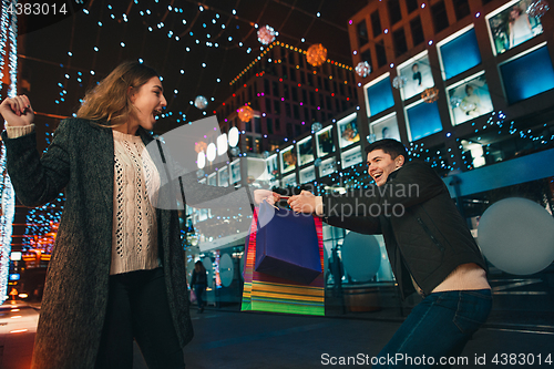 Image of The happy couple with shopping bags enjoying night at city background