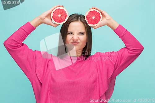 Image of Pretty woman with delicious grapefruit in her arms.