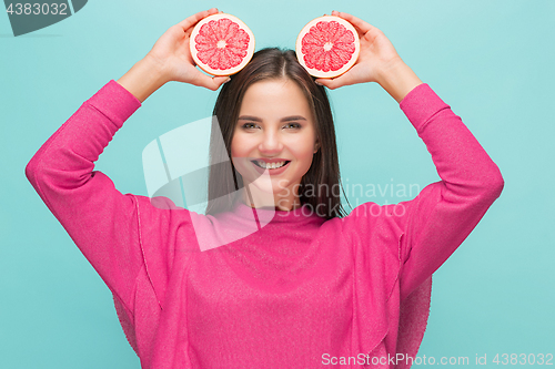 Image of Pretty woman with delicious grapefruit in her arms.