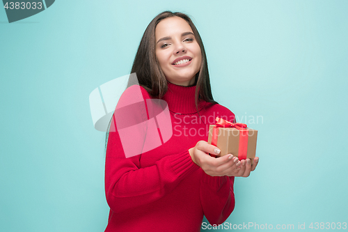 Image of Portrait of happy young woman holding a gift isolated on white