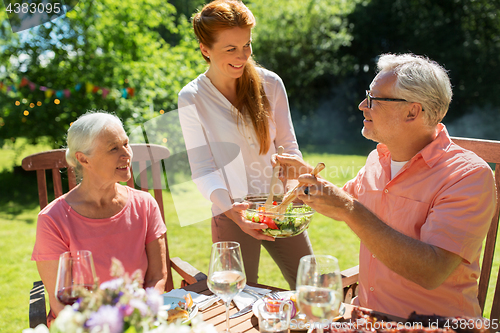 Image of happy family having dinner or summer garden party