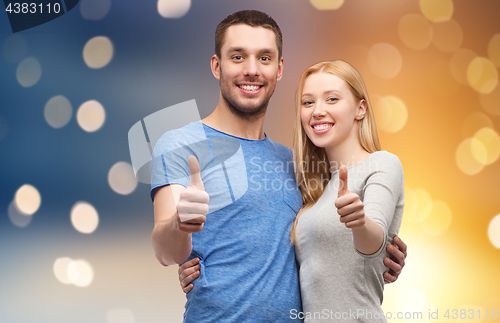 Image of happy couple hugging and showing thumbs up