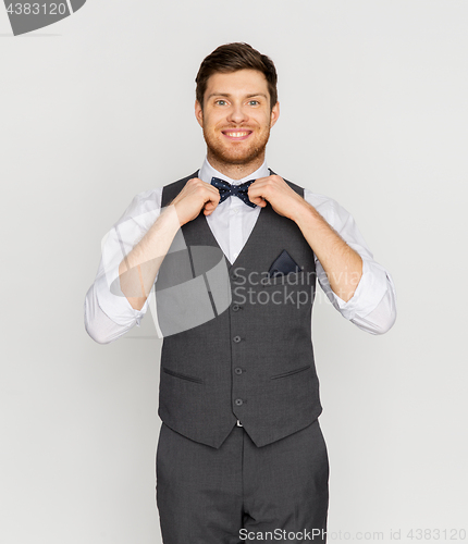 Image of happy man in festive suit dressing for party