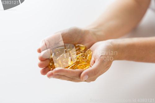 Image of hands holding cod liver oil capsules