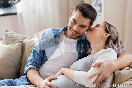 Image of man hugging pregnant woman at home