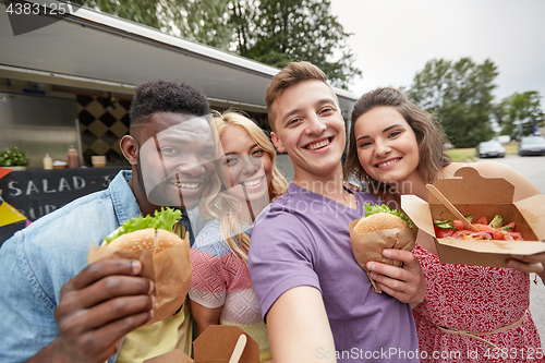 Image of happy friends taking selfie at food truck