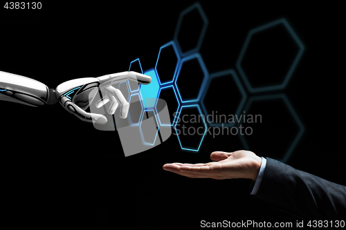 Image of human hand and robot touching network hologram