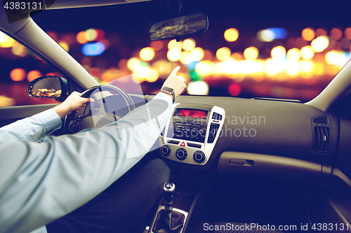 Image of close up of man driving car and pointing finger