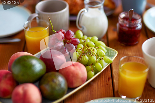 Image of fruits, juice and other food on table at breakfast