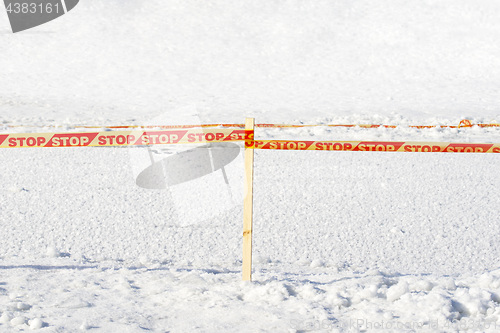 Image of Yellow STOP tape surrounded frozen ice hole