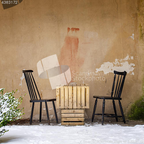 Image of table and two chairs near the wall