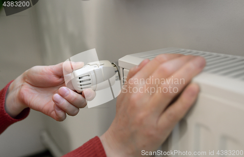 Image of Woman Adjusting Thermostat